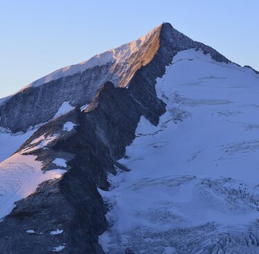 Majestätischer, schneebedeckter Berggipfel, beleuchtet vom warmen Abendlicht. | © Ferdinand Rieder