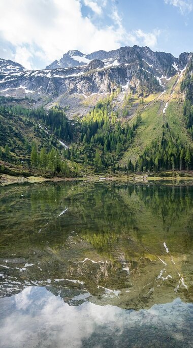 Spiegelung der Berge in einem klaren, ruhigen See, umgeben von Wäldern.  | © Tourismusverband Großarltal
