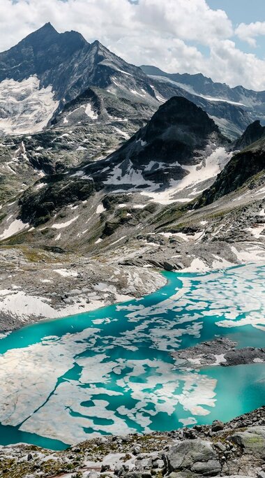 Türkisfarbener Gletschersee mit Eisplatten inmitten von schroffen Berggipfeln. | © Ferienregion Nationalpark Hohe Tauern