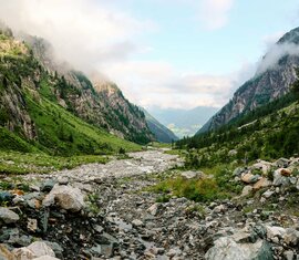 Weitläufiges Tal mit grünen Hängen, von Nebel und Bäumen umrahmt. | © Ferienregion Nationalpark Hohe Tauern